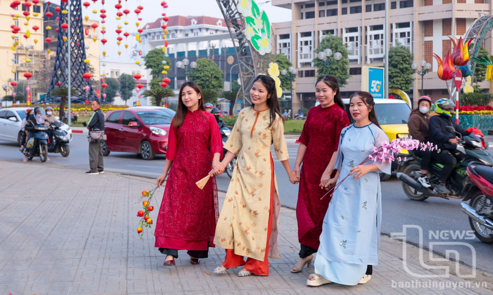 Phụ nữ dịu dàng trong tà áo dài đón Xuân.