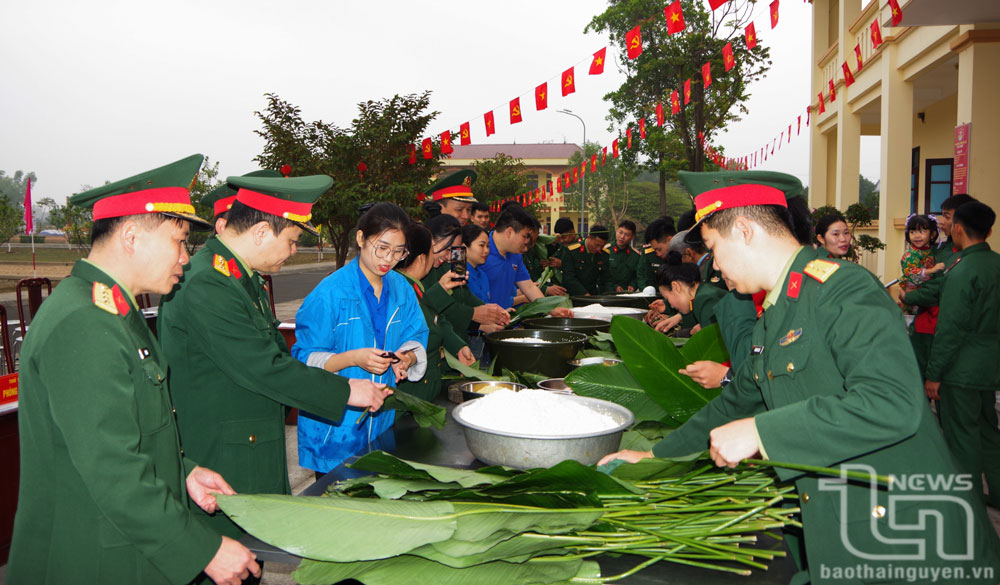 Cán bộ, chiến sĩ lực lượng vũ trang và đoàn viên, nhân dân tham gia gói bánh chưng.