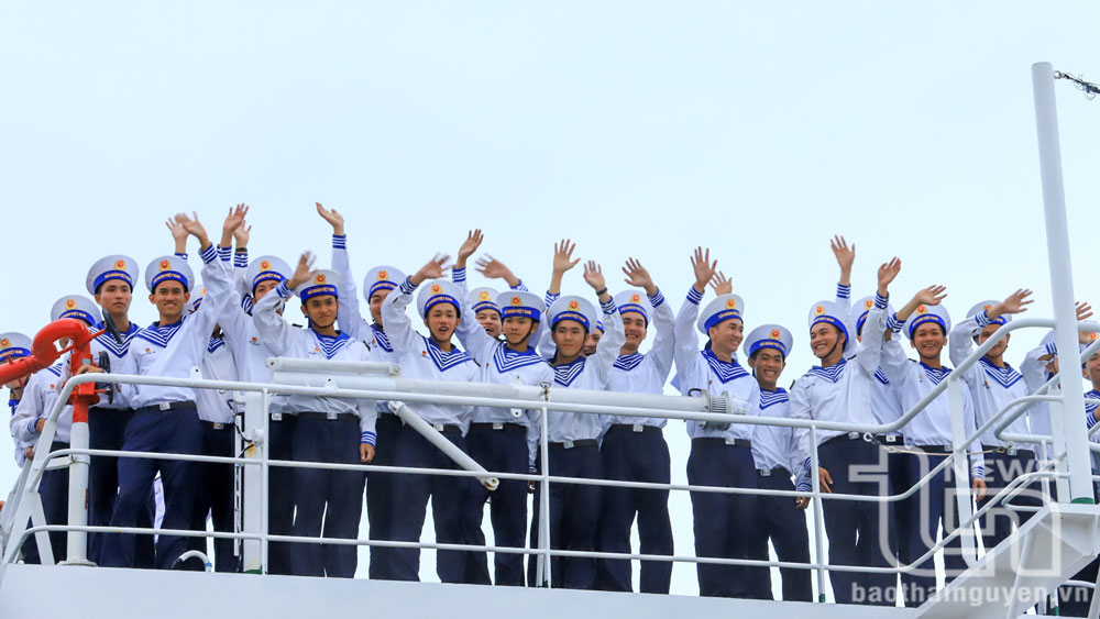 Những người lính hải quân trẻ trung đứng sát nhau kết thành hàng dài vững chắc trên boong tàu cùng vẫy chào đất liền và đồng đội trước giờ lên đường thực hiện nhiệm vụ.