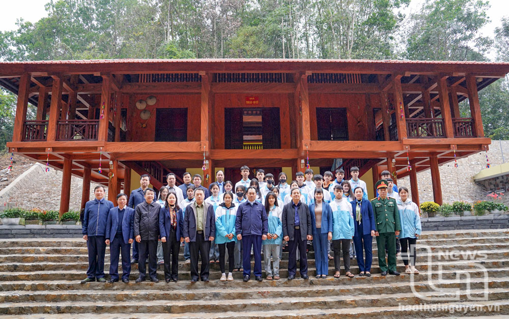 Các đại biểu cùng các em học sinh chụp ảnh lưu niệm tại Khu di tích lịch sử Quốc gia địa điểm thành lập Đội Cứu quốc quân II.