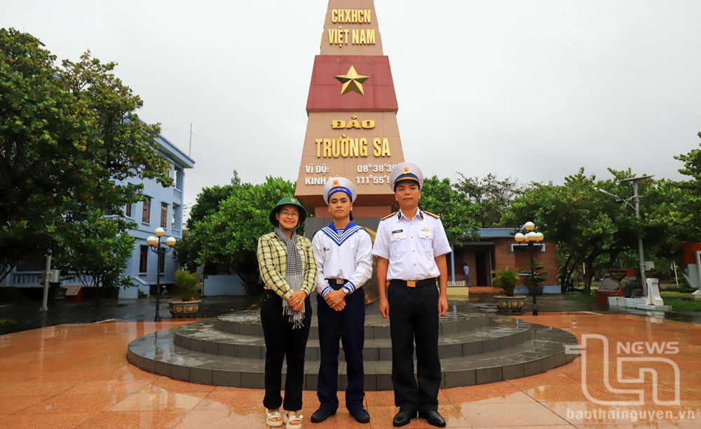 Tác giả chụp ảnh lưu niệm cùng chiến sĩ Phan Văn Khởi và Trung úy Trần Hải Anh bên cột mốc chủ quyền của đảo Trường Sa.
