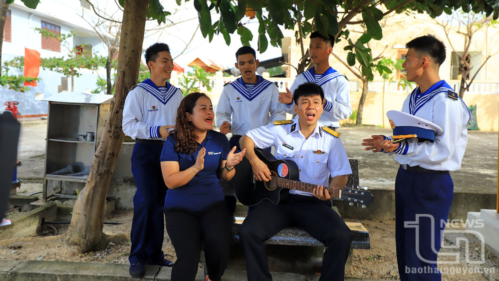 Trung úy Trần Văn Hoàng (người đánh đàn) - chàng trai người Thái Nguyên, hát cùng đồng đội và một nữ thành viên trong Đoàn công tác.