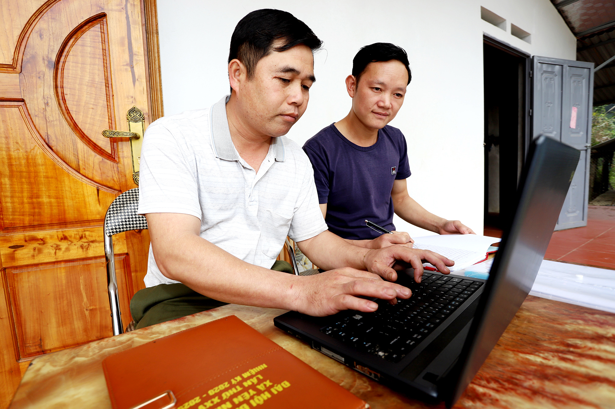 Trên nền tảng Internet cáp quang băng thông rộng do VNPT cung cấp, anh Trần Văn Phong (bên trái), Phó trưởng xóm Ba Họ có thể sử dụng máy vi tính để báo cáo công việc định kỳ với UBND xã Yên Ninh.