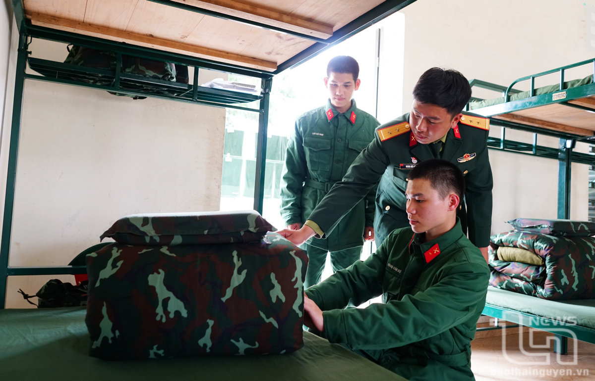 Chỉ huy Trung đội hướng dẫn chiến sĩ mới của Lữ đoàn Pháo binh 382 gấp chăn màn.