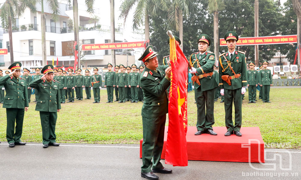 Thiếu tướng La Công Phương gắn Huân chương Bảo vệ Tổ quốc hạng Ba lên lá cờ truyền thống của Bộ CHQS tỉnh.