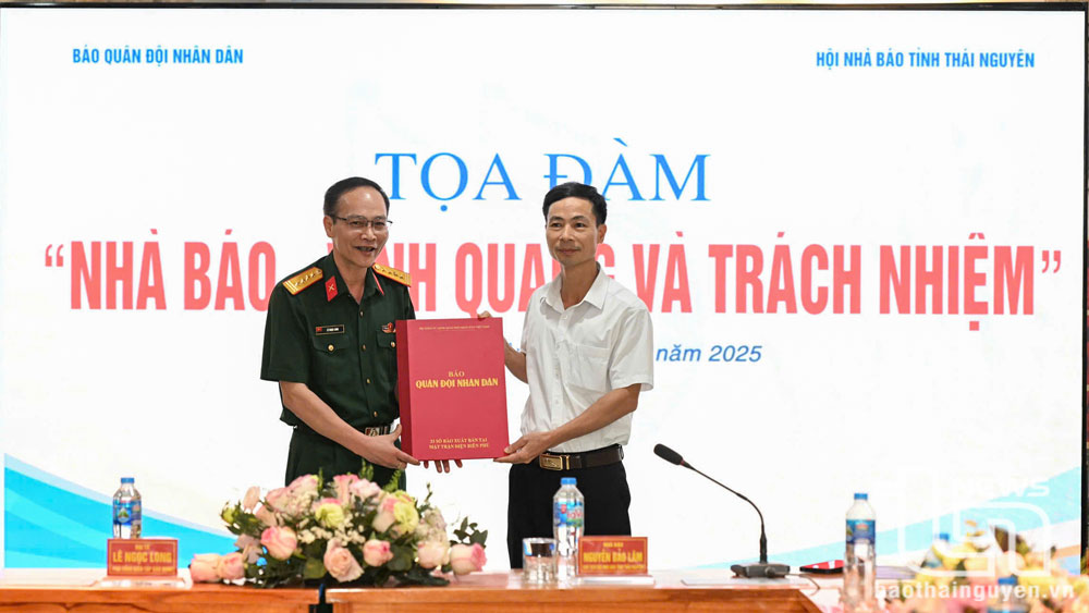 Đại diện lãnh đạo Báo Quân đội nhân dân tặng quà Ban quản lý Di tích Trường dạy làm báo Huỳnh Thúc Kháng.