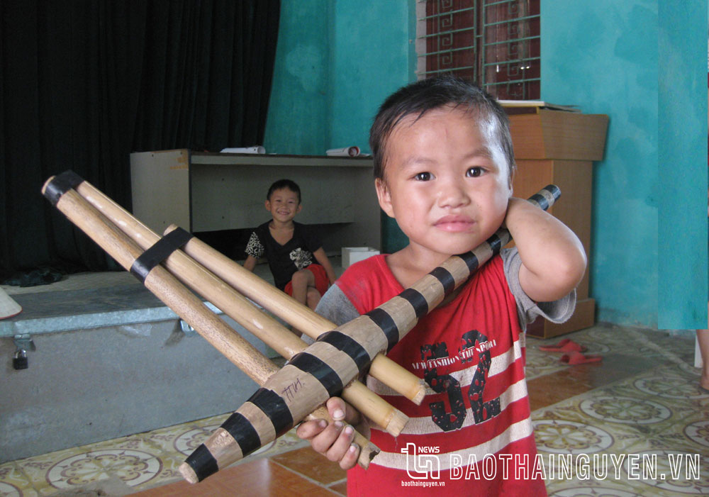 Một em bé người Mông ở Văn Lăng (Đồng Hỷ) và chiếc khèn.