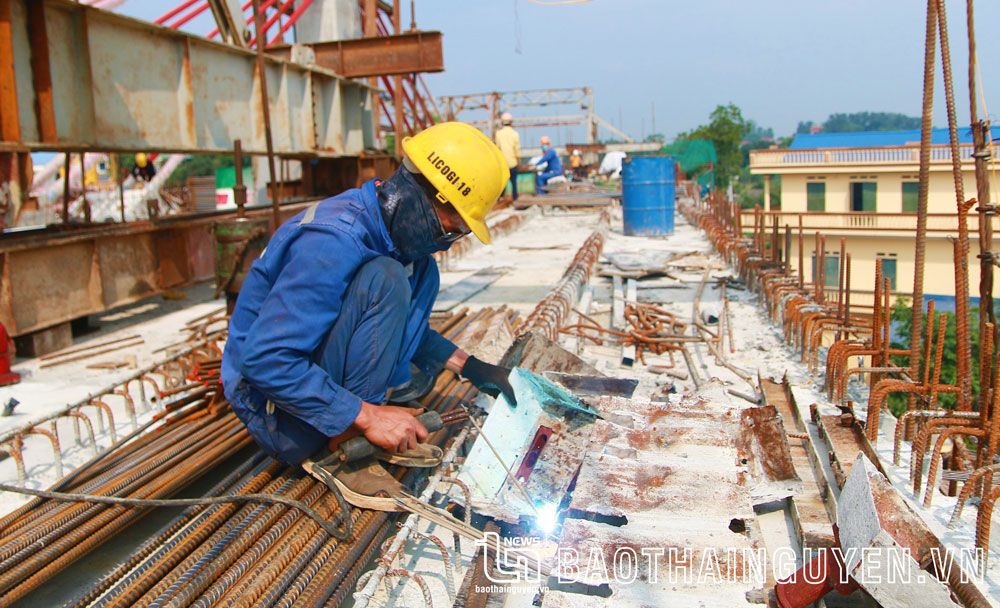 Một công nhân gia công kết cấu thép để chuẩn bị đổ bê tông phần mặt cầu.