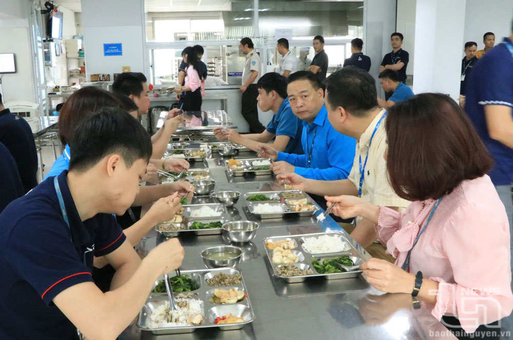 Các thành viên trong Đoàn công tác dự bữa cơm ca với người lao động.