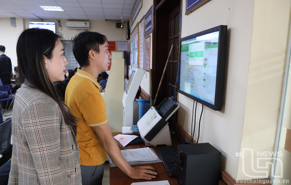 Cán bộ tại Bộ phận tiếp nhận và trả kết quả TP. Phổ Yên hướng dẫn người dân tra cứu thông tin về thủ tục hành chính trên mạng.