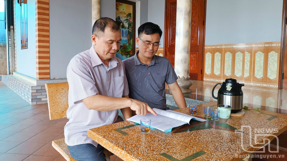 Đồng chí Bí thư Chi bộ tổ dân phố 3 (áo kẻ) trao đổi với cán bộ xã về một số nội dung cần huy động sức dân của tổ dân phố.