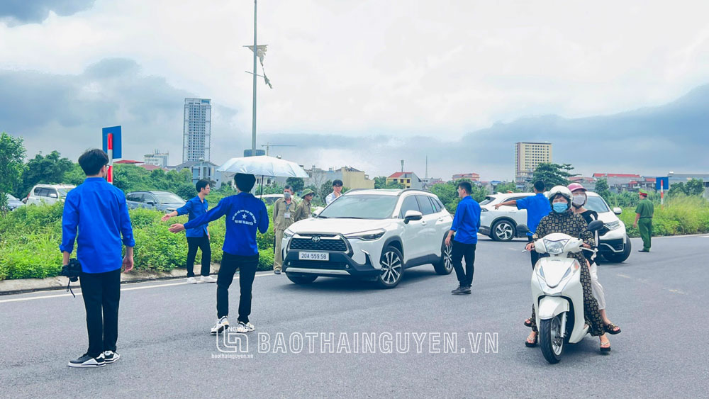 Tình nguyện viên hỗ trợ phân luồng giao thông tại điểm thi Trường THPT Chuyên Thái Nguyên.