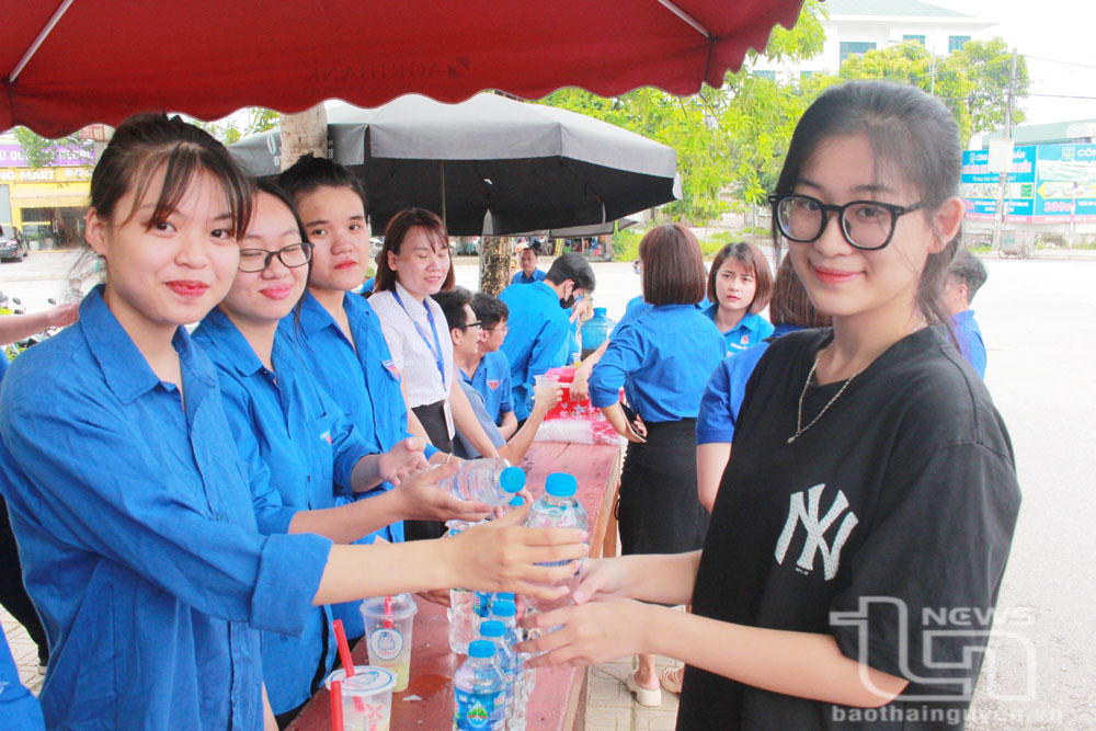Lực lượng tình nguyện viên phát nước uống miễn phí cho thí sinh tại điểm thi Trường THPT Ngô Quyền (TP. Thái Nguyên).