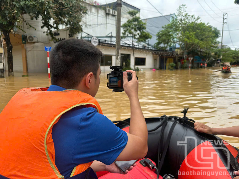 Phóng viên Lăng Khoa (Báo Thái Nguyên) ghi hình tại rốn lũ.
