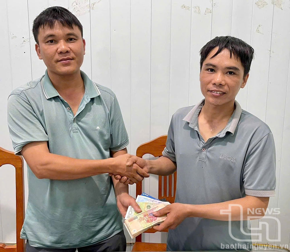 Anh Lê Đức Lợi (bên trái) trả lại số tiền hơn 20 triệu đồng cho anh Nguyễn Văn Điều.
