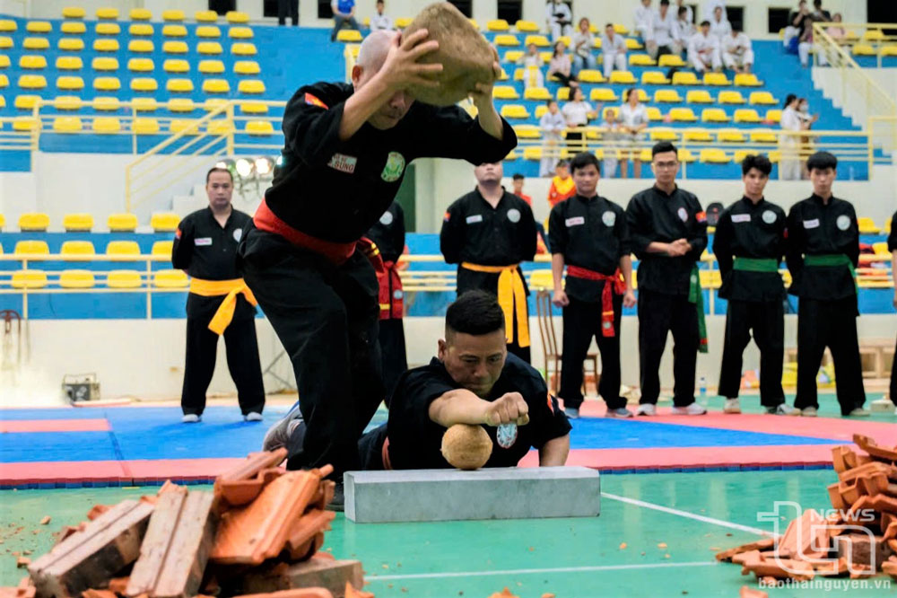 Các võ sư dùng tảng đá lớn đập vào tay để làm vỡ quả dừa khô bên dưới.