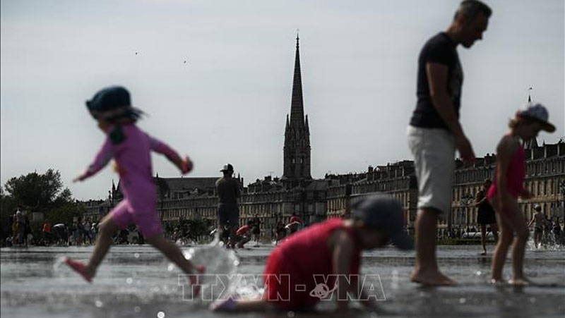 Người dân giải nhiệt tránh nóng tại khu vực đài phun nước ở Bordeaux, Pháp. Ảnh tư liệu: AFP/TTXVN