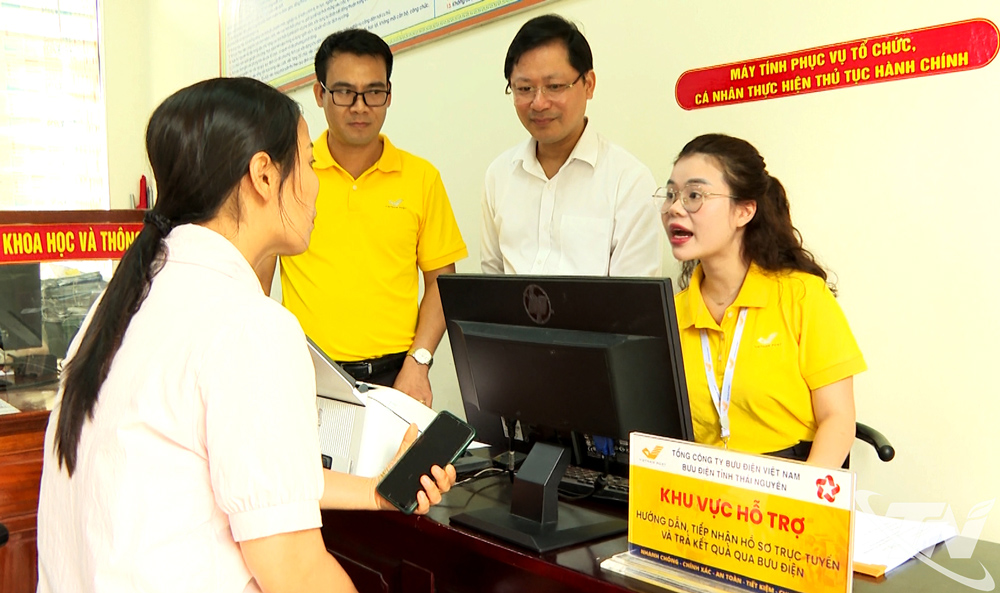 Nhân viên bưu điện hướng dẫn người dân thực hiện thủ tục hành chính tại Trung tâm Phục vụ hành chính công xã Đồng Hỷ.