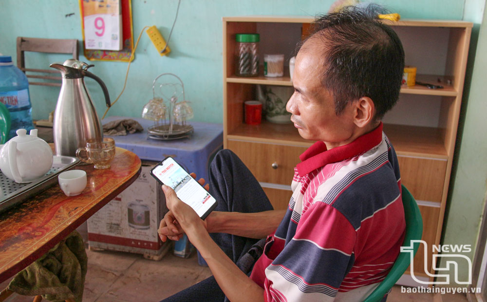 Nhờ có điện thoại kết nối 4G, anh Phạm Văn Tình, xóm Đồng Bốn, xã Tân Thành có thể cập nhập các tin tức mọi lúc, mọi nơi.