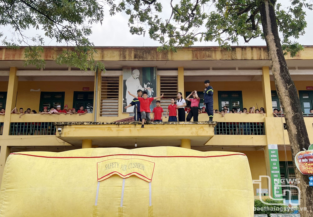 Học sinh Trường Tiểu học Nguyễn Huệ (TP. Thái Nguyên) thực hành, trải nghiệm thoát nạn bằng đệm hơi.