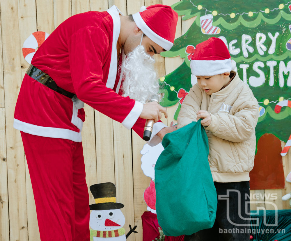 Các em nhỏ thích thú khi được ông già Noel tặng quà.