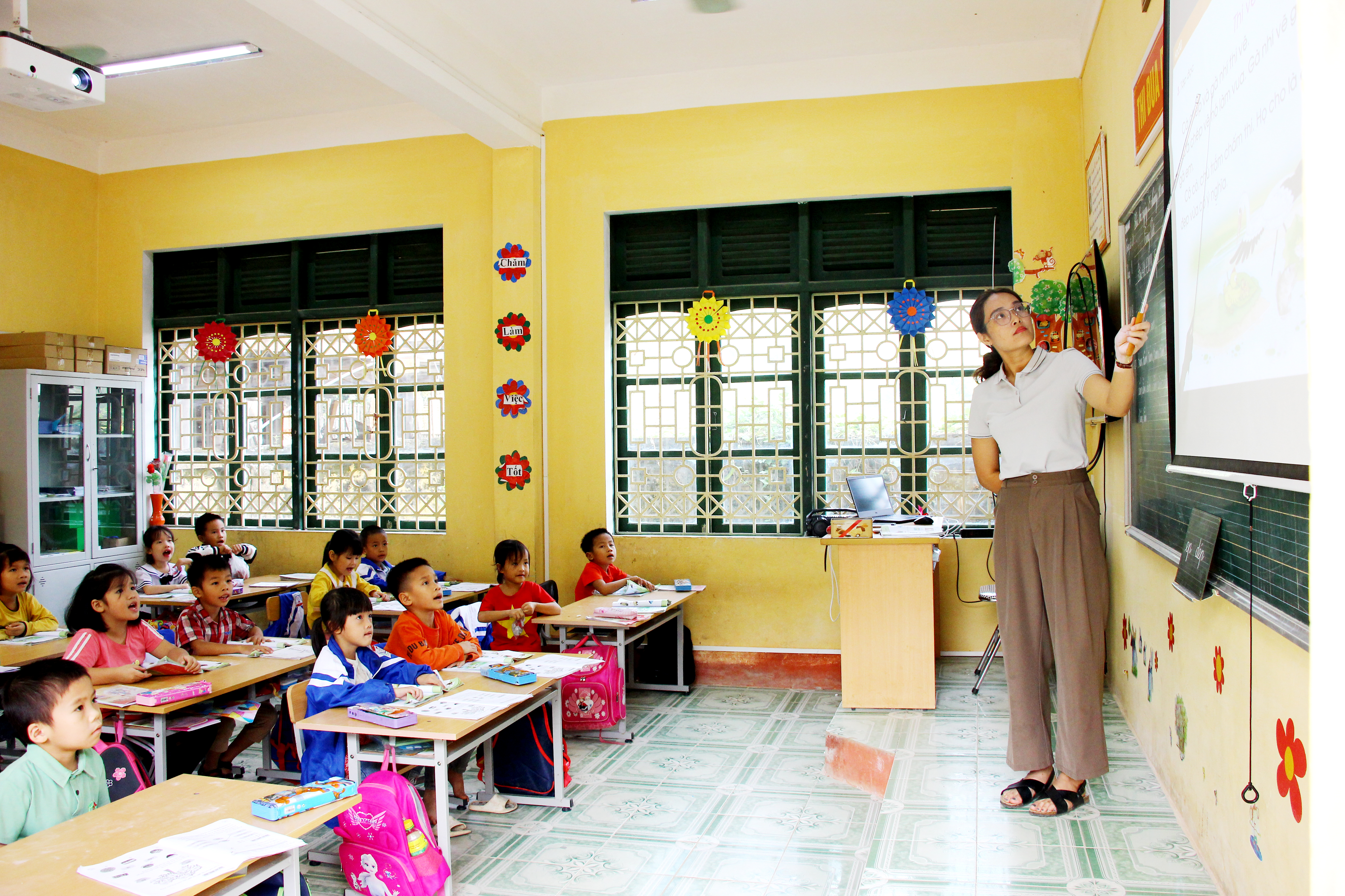 Trường Tiểu học Vũ Chấn đã sử dụng máy chiếu để nâng cao chất lượng bài giảng. Trong ảnh: Cô giáo Lý Thị Bích Ngọc trong giờ dạy học sinh lớp 1.

